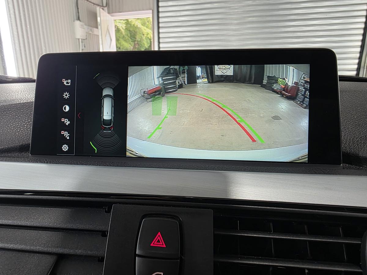 Reversing camera view with parking guide lines on a BMW's factory screen
