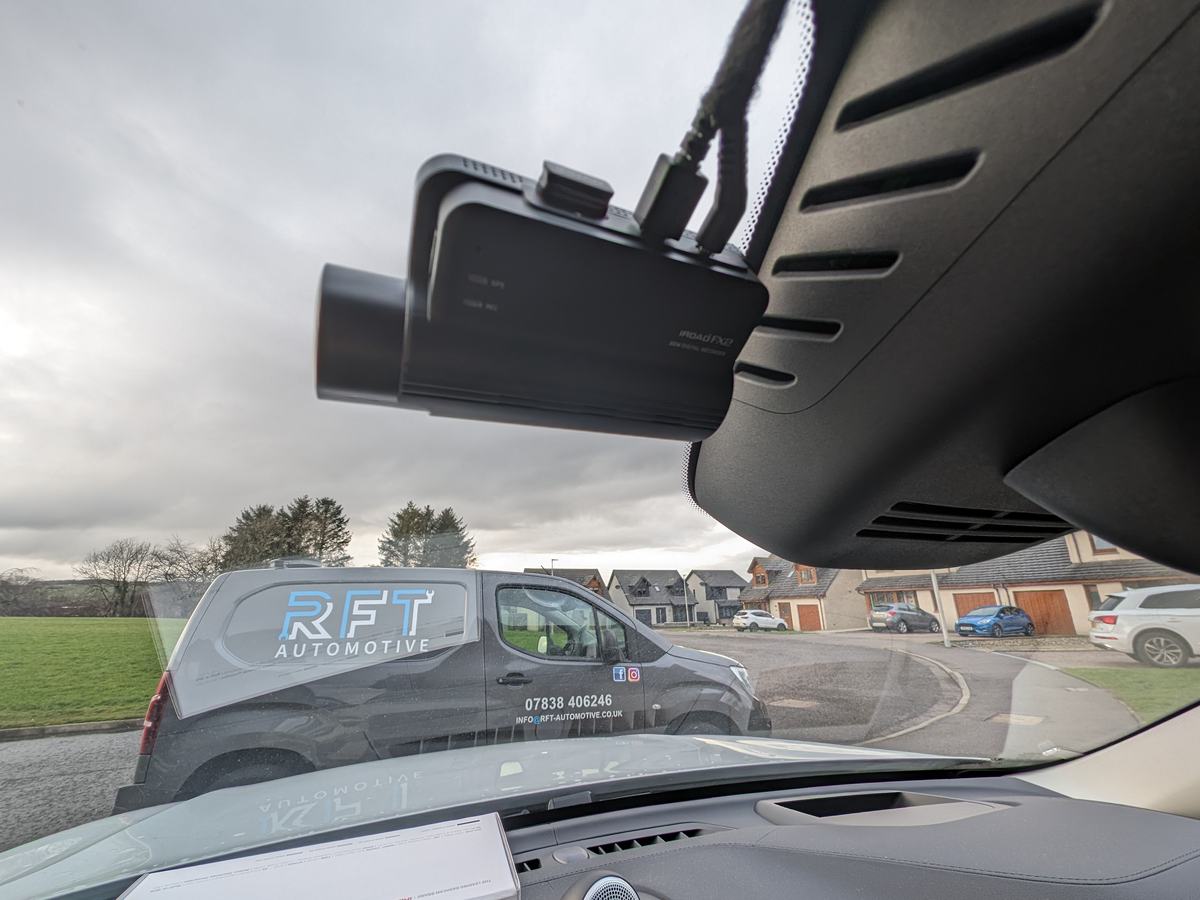 iRoad dash cam neatly fitted behind the rear-view mirror, with the RFT Automotive van parked outside